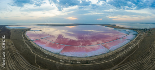 The pink lake is stained with Dunaliella salina bacteria. Panorama.