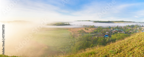 sunrise, fog over the river panorama of the landscape in the early morning. thick fog is illuminated by the sun's rays in summer