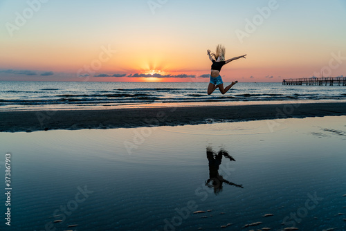 girls jump on the beach in sunrise time