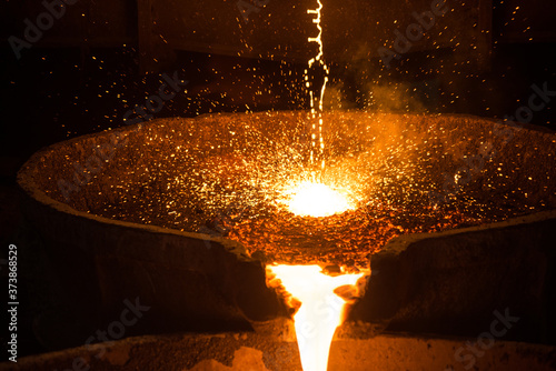 Pouring liquid metal from arc furnace photo