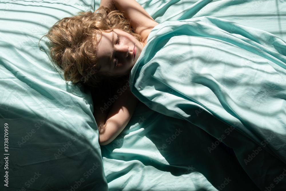 Caucasian child kid sleeping in the morning on a pillow under a blanket on the bed. Caucasian child kid sleeping in the morning on a pillow under a blanket on the bed.