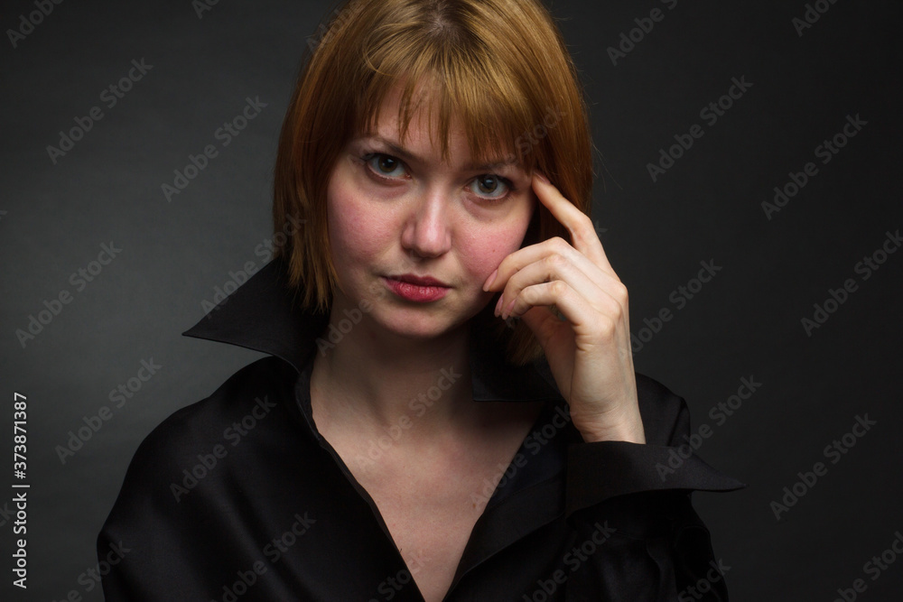 A young woman with short blonde hair. Studio portrait on a black background. A young woman with short blonde hair. Studio portrait on a black background.