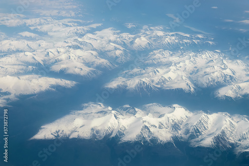 View from airplane on Earth surface - snow-capped mountains.