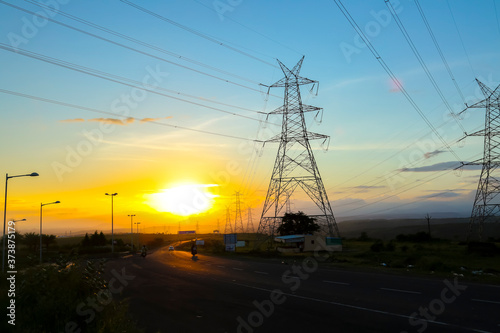 high-voltage power lines at sunset,high voltage electric transmission tower © Niks Ads