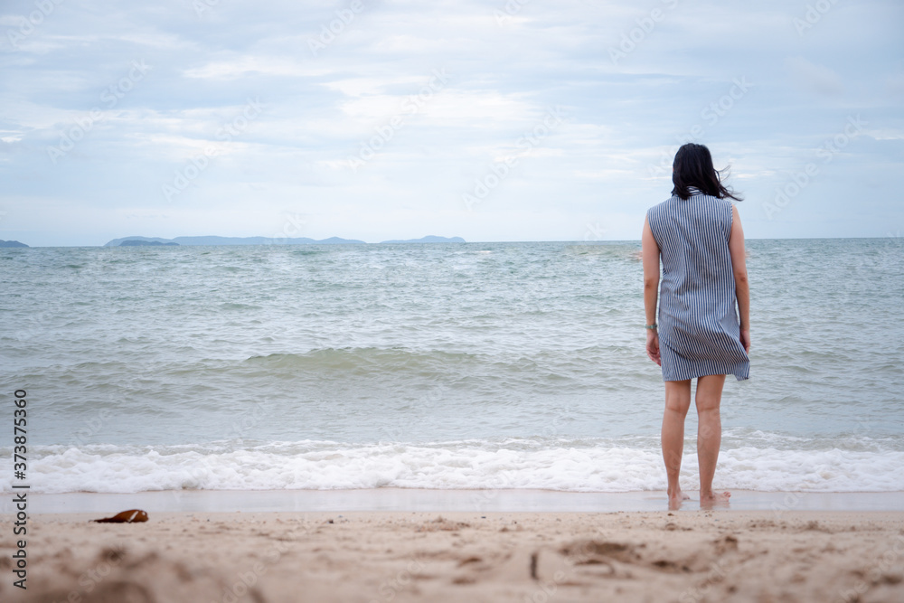 Asian woman walking alone on the beach. concept for holiday vacation and relaxing.