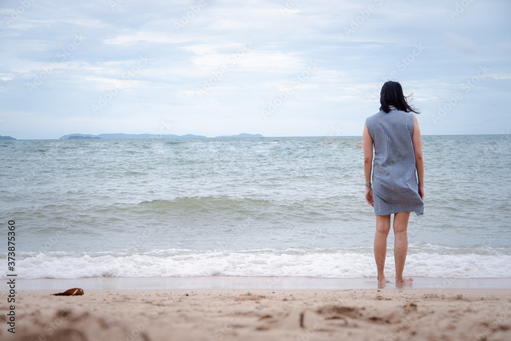 Asian woman walking alone on the beach. concept for holiday vacation and relaxing. Asian woman walking alone on the beach. concept for holiday vacation and relaxing.