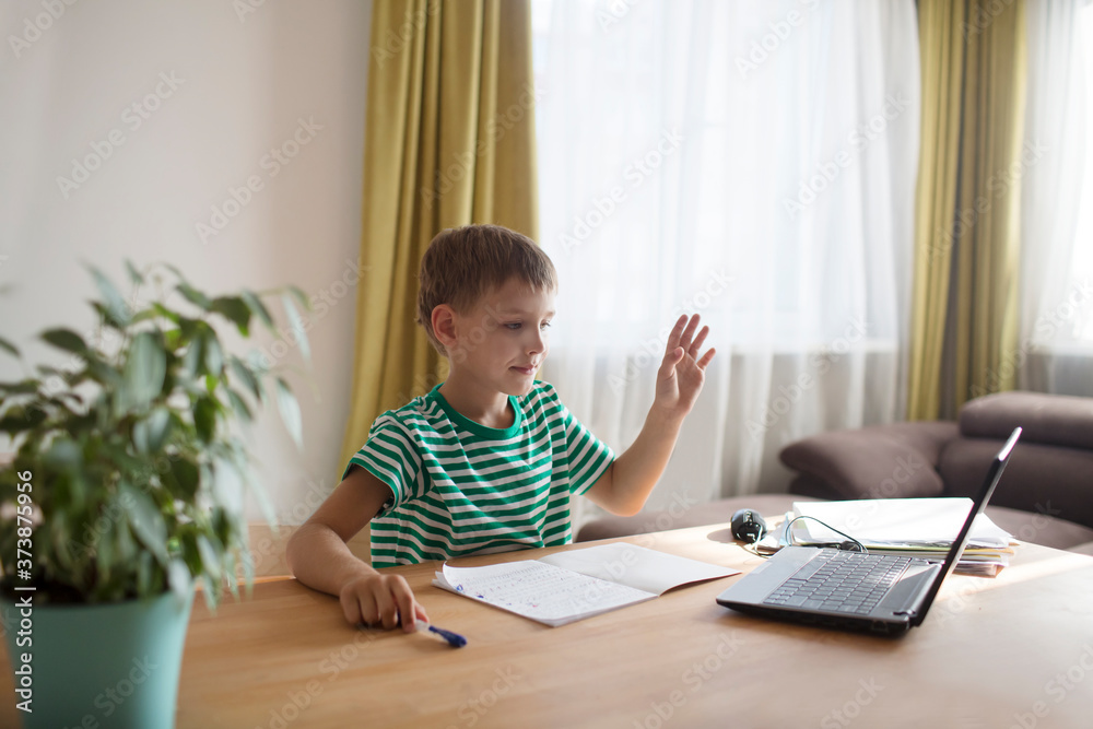 Preteen schoolboy doing his homework with laptop at home. homeschooling, distant learning Preteen schoolboy doing his homework with laptop at home. homeschooling, distant learning