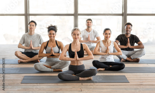 International Yoga Class. Group Of Sporty Millennial People Sitting In Lotus Position