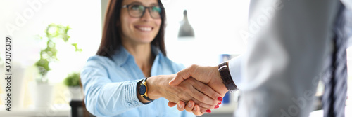 Business woman in office shakes hands with business partner. Mutually beneficial cooperation concept photo