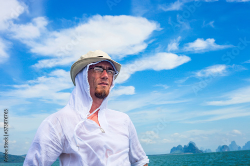 Young man portrait against blue sea, summer vacations