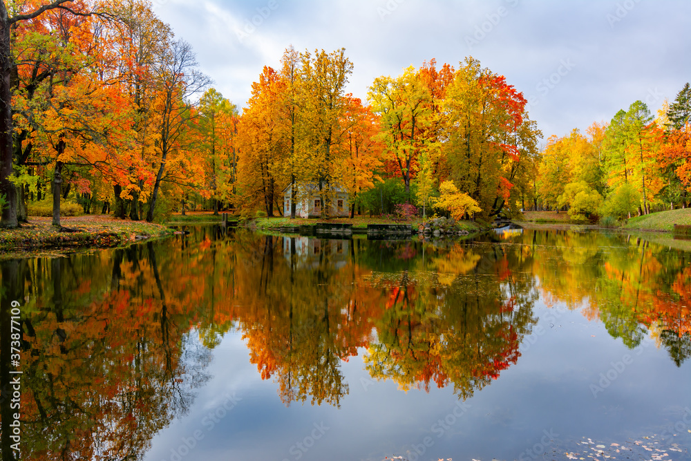 Children's house in autumn foliage reflected in pond in Alexander park, Tsarskoe Selo (Pushkin), St. Petersburg, Russia Children's house in autumn foliage reflected in pond in Alexander park, Tsarskoe Selo (Pushkin), St. Petersburg, Russia
