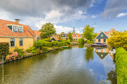 Yndyk, Hindeloopen, province of Friesland, municipality Súdwest-Fryslân, Netherlands, september 3, 2017: View to houses and boats at canal Yndyk seen from bridge at Nieuwe Weide