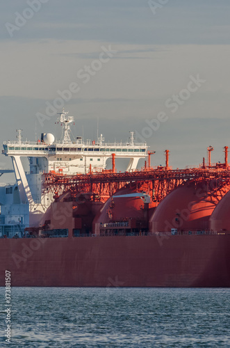 LNG TANKER - The red ship goes to the seaport photo