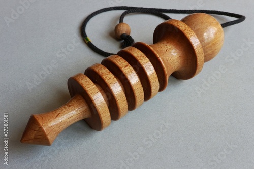 Wooden dowsing pendulum(izis)on gray background photo