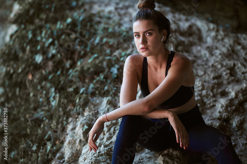 Sweaty woman posing in mountains. Comfy sportswear. Outdoors workout. Copy space