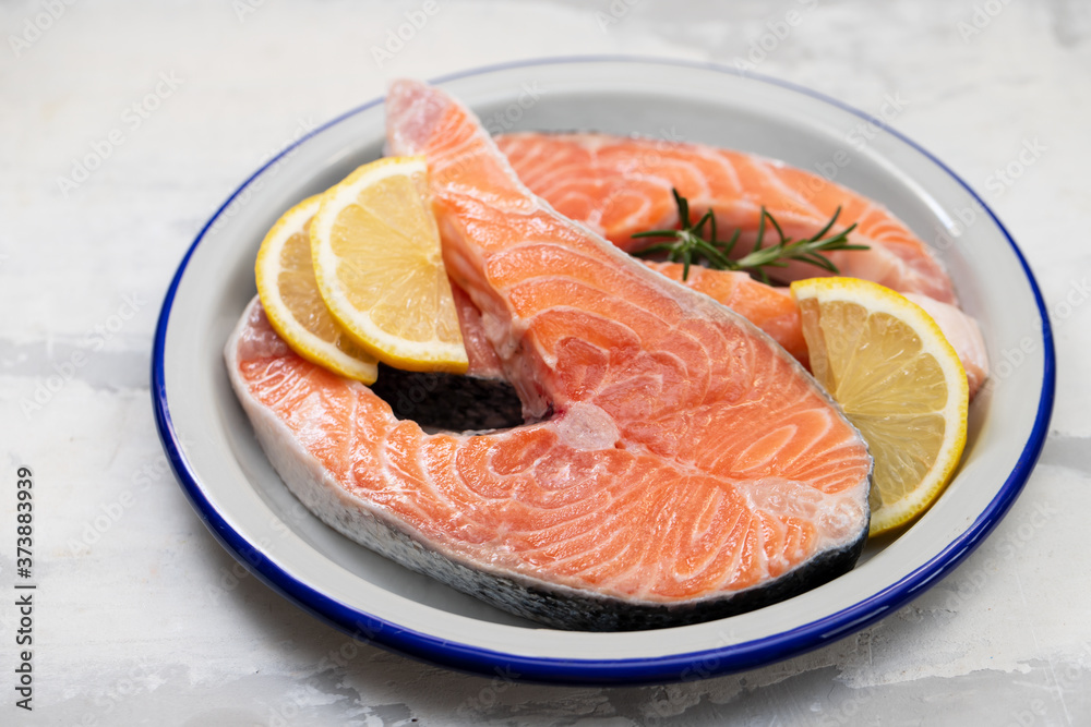 fresh raw salmon on the dish on ceramic background fresh raw salmon on the dish on ceramic background