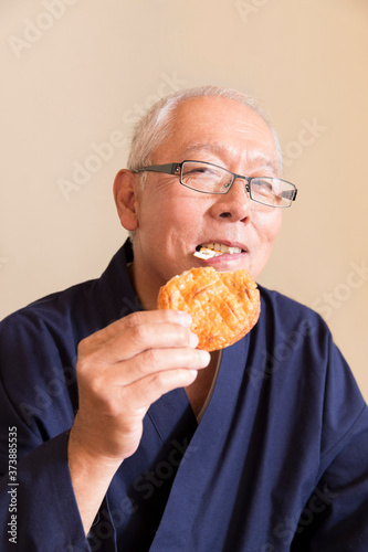 煎餅を食べるシニア男性