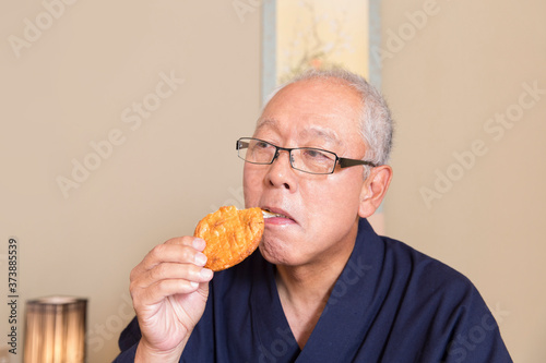 煎餅を食べるシニア男性