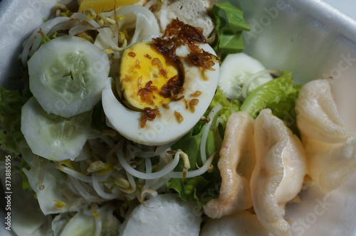 Gado-gado (Indonesian) is traditional indonesian food. rice cake, egg and vegetable with peanut sauce. Selective Focus.      photo