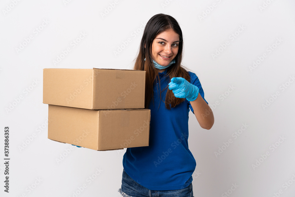 Young delivery woman protecting from the coronavirus with a mask isolated on white background points finger at you with a confident expression Young delivery woman protecting from the coronavirus with a mask isolated on white background points finger at you with a confident expression