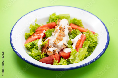 fresh salad with grilled chicken and sauce on the plate