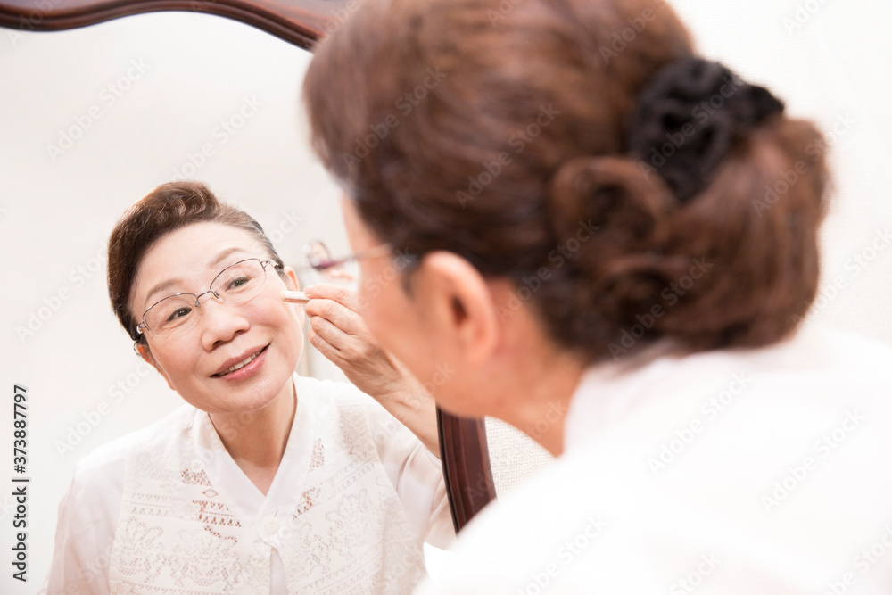 Obraz premium 化粧をするシニア女性