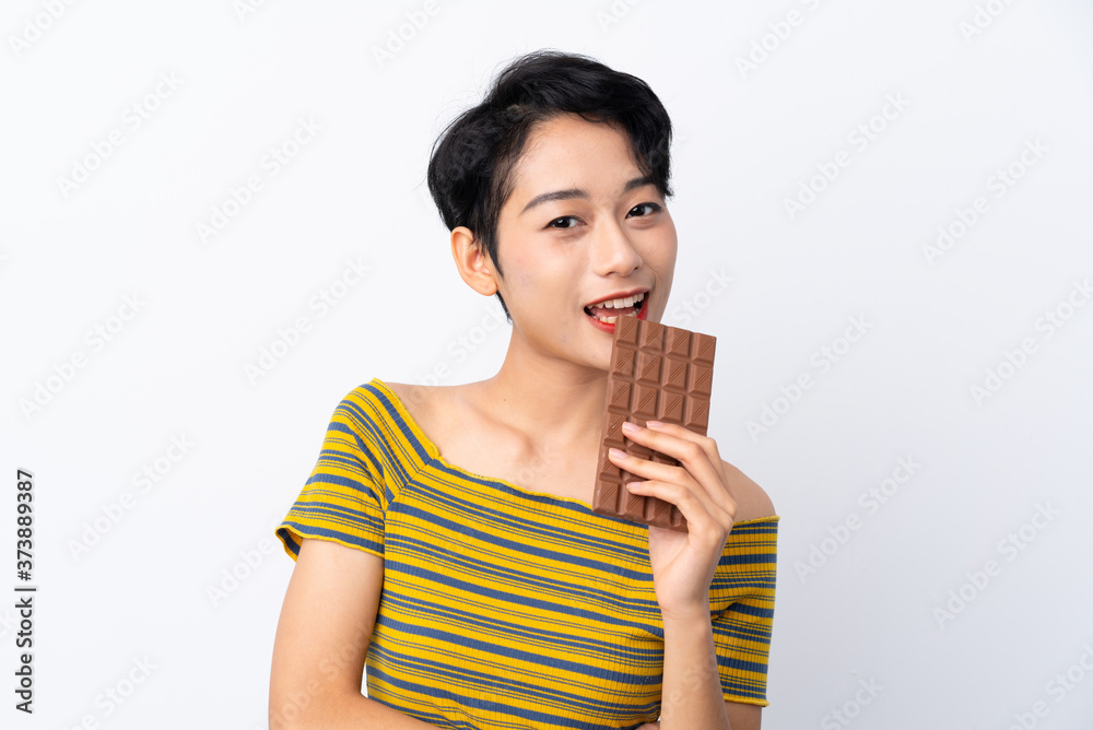 Young Asian girl taking a chocolate tablet and happy Young Asian girl taking a chocolate tablet and happy
