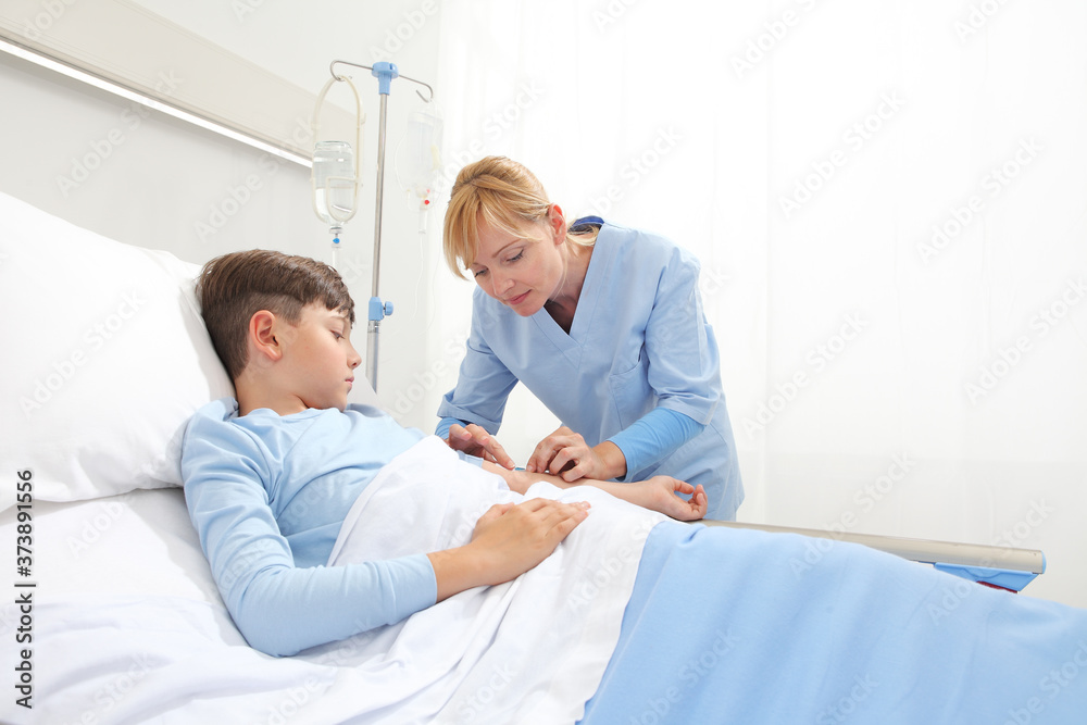 Nurse medicating sick and afraid child lying in bed in hospital room and getting him the drip Nurse medicating sick and afraid child lying in bed in hospital room and getting him the drip
