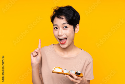Young Asian girl with sushi pointing up a great idea