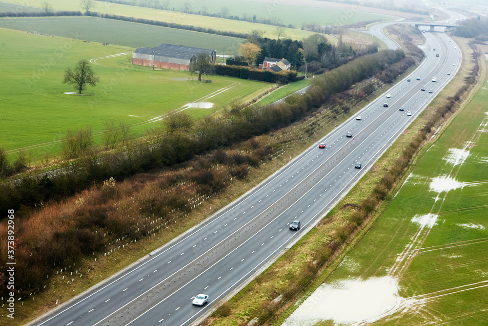 Aerial view of the M11 motorway running through the farmland of Cambridgeshire