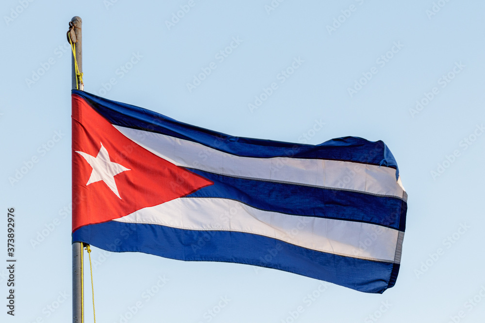 Obraz premium Flag of cuba waving with flagpole and blue sky