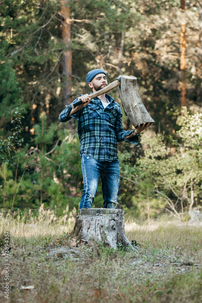 Stylish bearded forester chopping wood with an axe