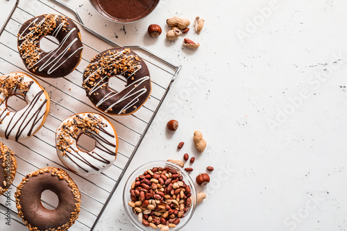 Cooling rack with tasty donuts on light background © Pixel-Shot