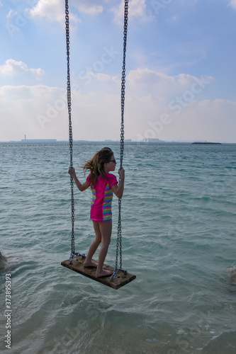 girl on a swing at low tide