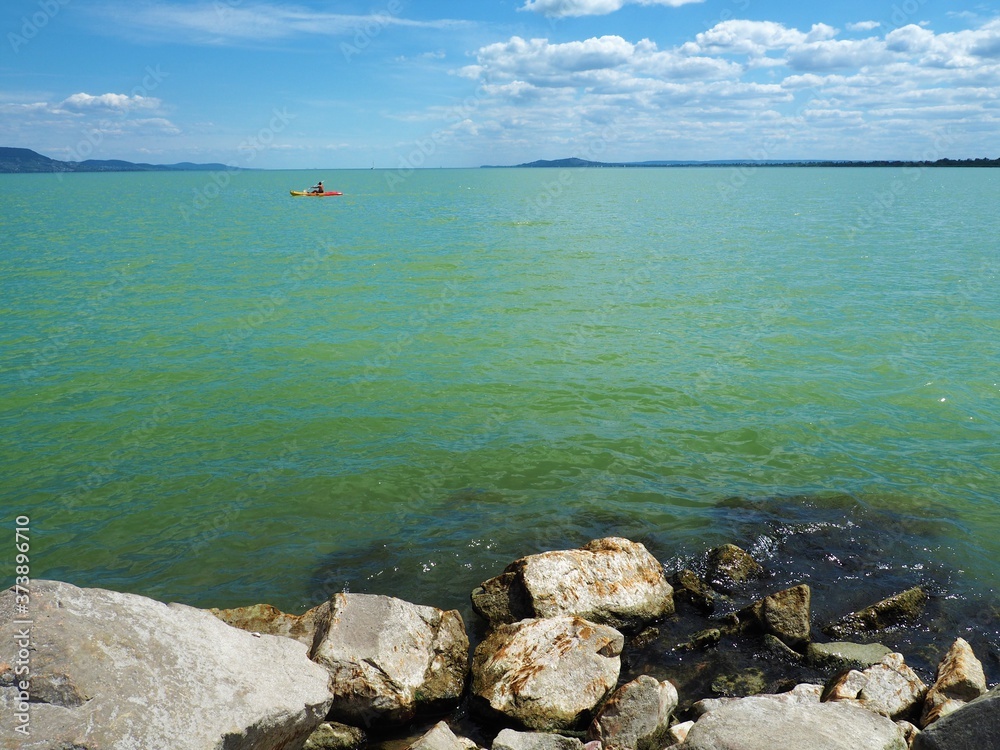 View of the lake Balaton with a canoeing from the stony shore in Hungary