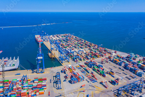 Container ship in export and import business and logistics. Shipping cargo to harbor by crane. Water transport International. Aerial view and top view.