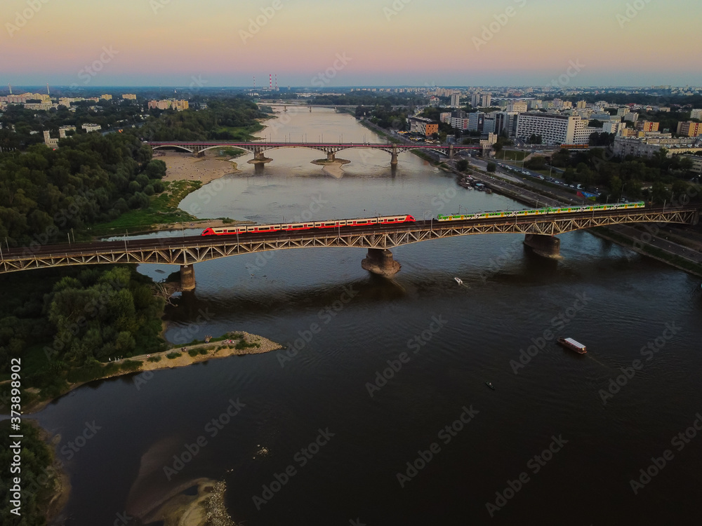 Capital cityscape and a suspension bridge over a large river. Drone, aerial view