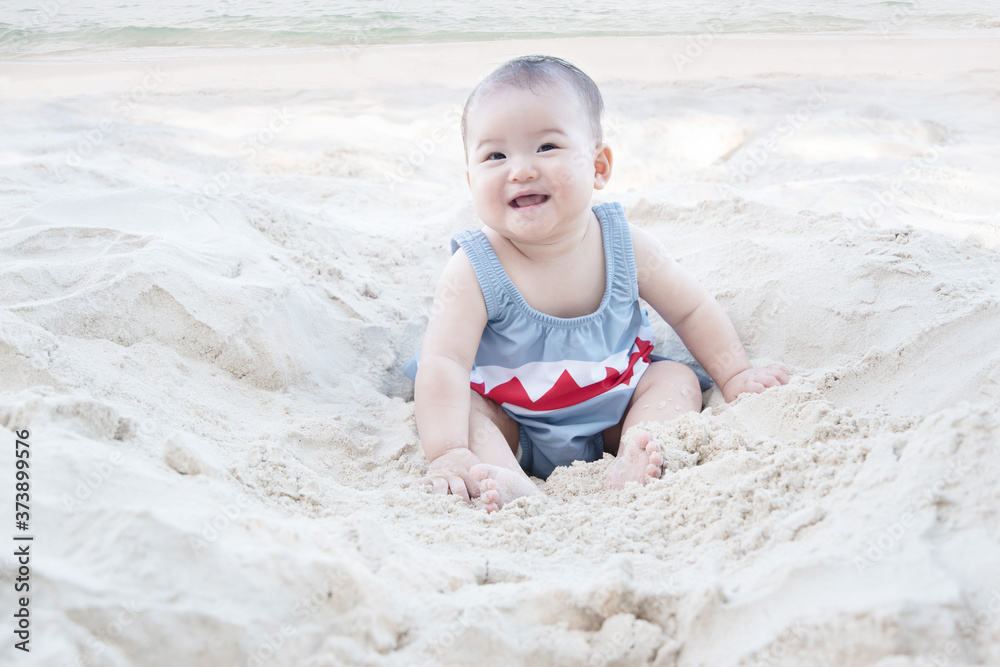 Asian Baby Smiling and Sitting on a Beach Asian Baby Smiling and Sitting on a Beach