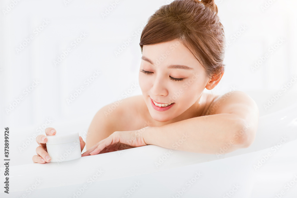 Woman in bathtub and showing blank bathing product Woman in bathtub and showing blank bathing product