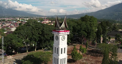Epic Drone Shot of Big Clock Jam Gadang Bukittinggi and Its Beautiful Background | A clock tower, in the centre of the city, near the main market, Pasar Ateh. It has large clocks on each face. photo