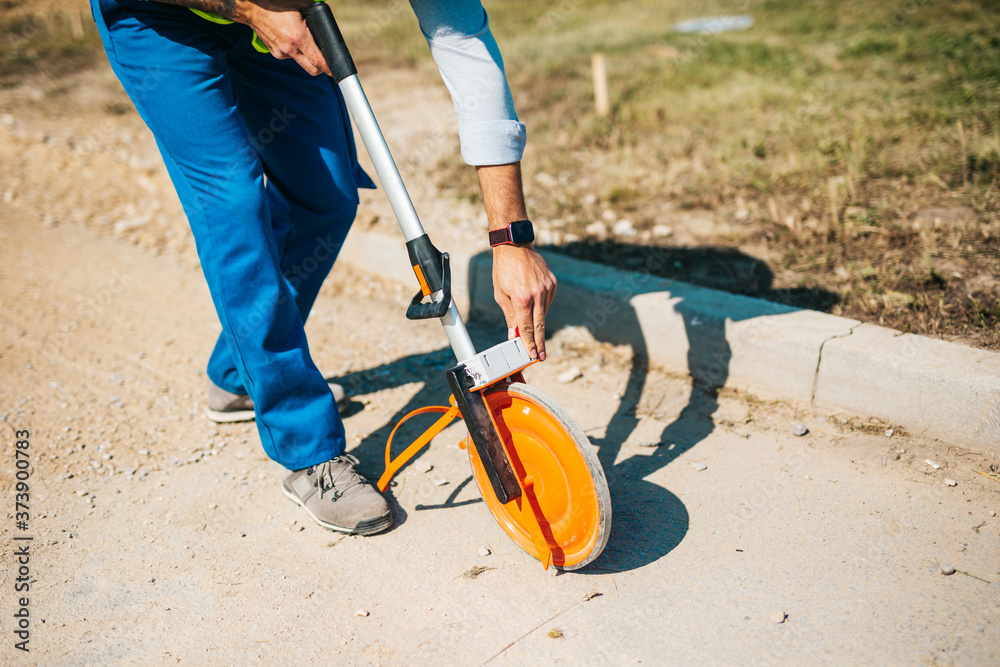 Obraz premium Young male road construction worker on his job. Bright sunny day. Strong light.