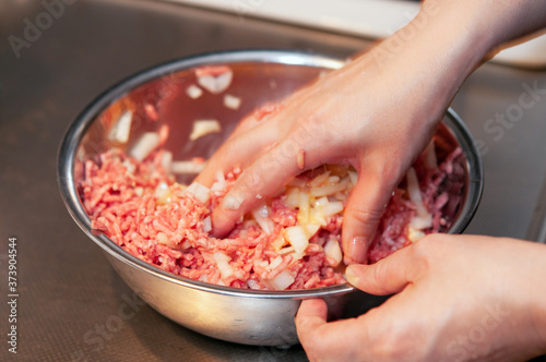 ハンバーグの材料をこねる女性の手