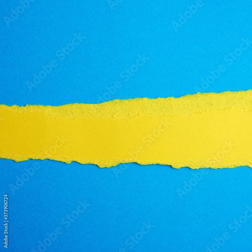 abstract background with torn edges of yellow paper  blue backdrop