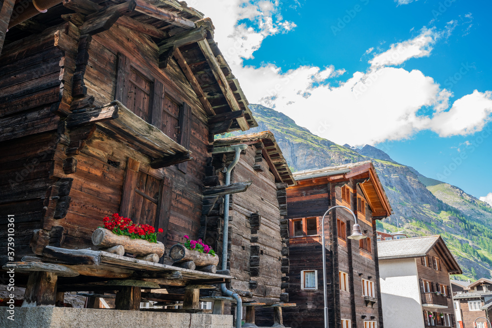 Ancient wooden traditional Swiss raccard granary on stone piles in Zermatt Switzerland