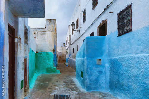View of the colorful old walls of Tetouan Medina quarter in Northern Morocco. A medina is typically walled, with many narrow and maze-like streets and often contain historical houses, palaces, places. © Renar