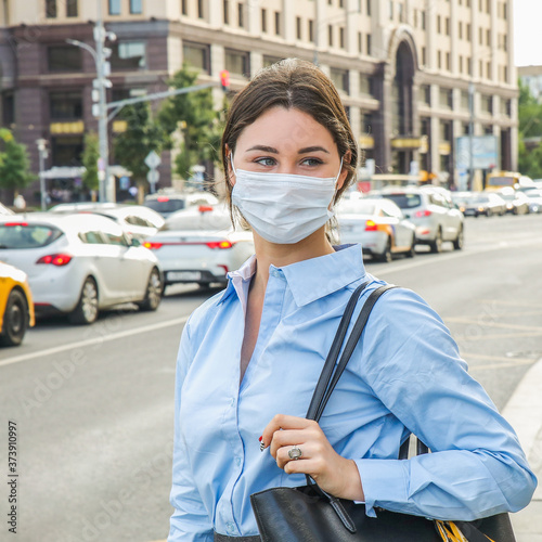 a girl in a protective mask stands on the street