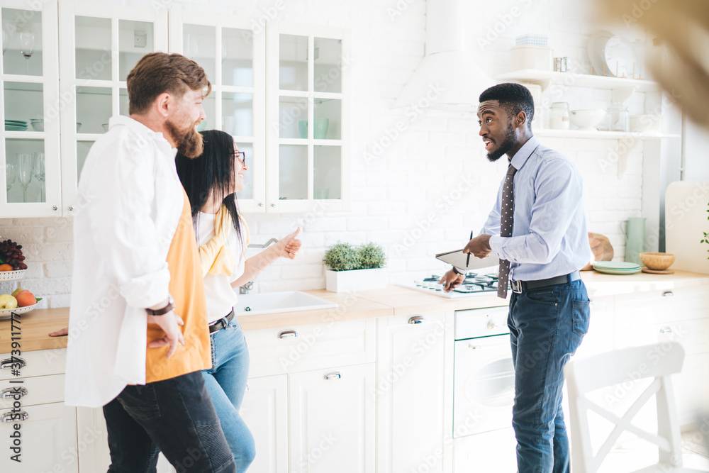 Fototapeta premium Male realtor demonstrating kitchen to couple
