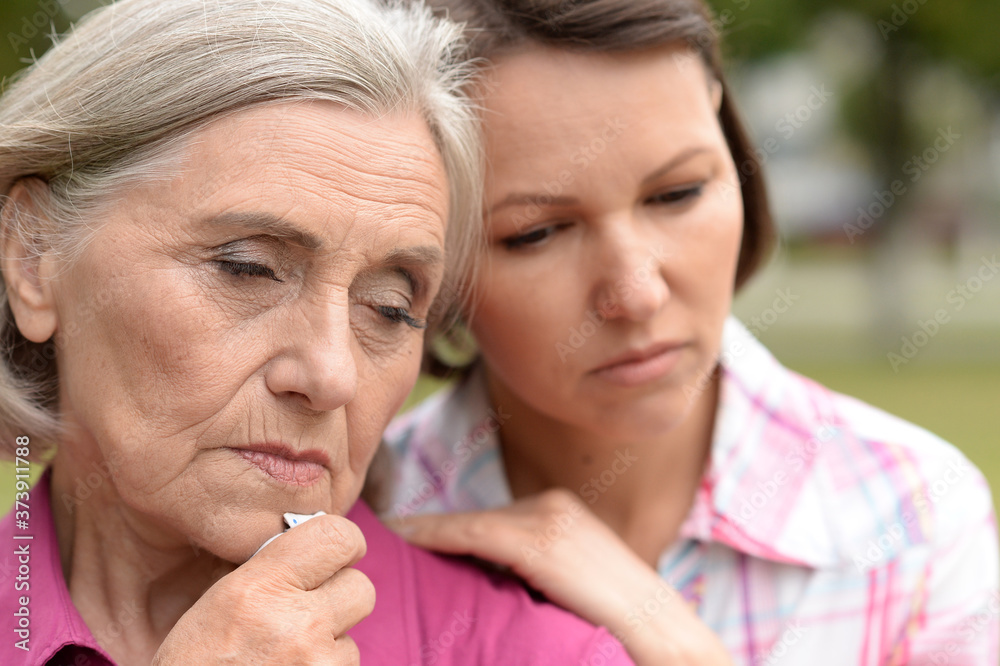 Close up portrait of sad senior woman with adult daughter Close up portrait of sad senior woman with adult daughter