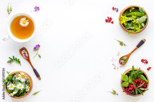 Top view of herbal tea in cup with herbs in bowls, top view