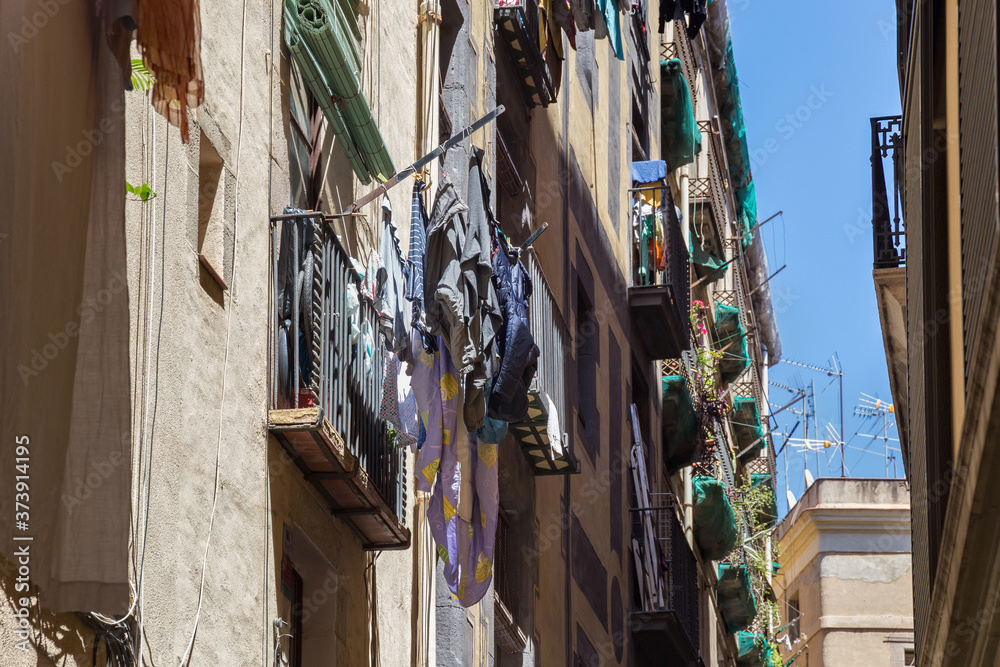 Traditional drying clothes of the local people in the historic famous Gothic quarter of Barcelona in sunny day. Spain.